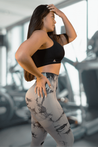 Woman in black sportswear showing side pose