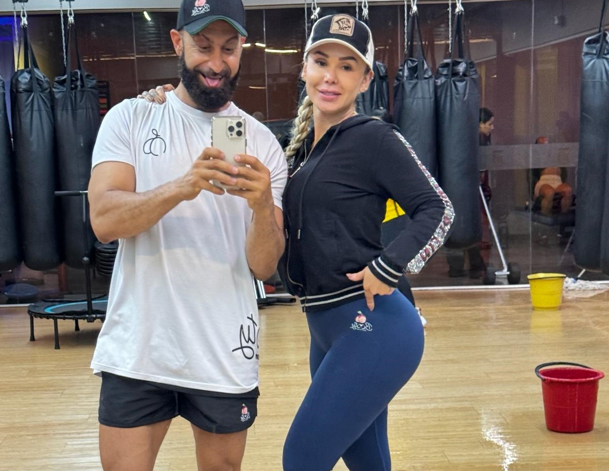 Glute coach Navid Moravej with a female client showing long-term BBL and glute training results at the gym
